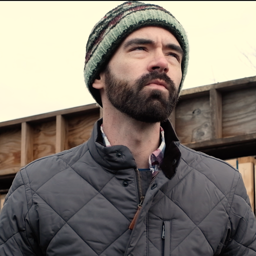 Photo of Brian Sanders outdoors in a puffy jacket and knit cap